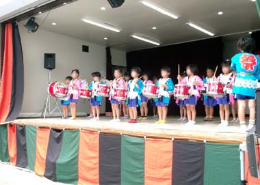 是政八幡神社境内の舞台上で器楽演奏をする園児たち