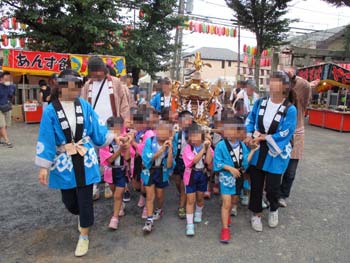 八幡神社境内でおみこしをかつぎ、練り歩く子ども達