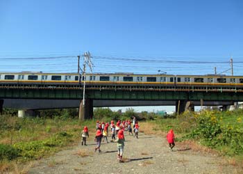 鉄橋を通過する電車にみんなで手を振る３歳児たち
