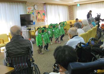 たくさんの施設利用者の皆さんの前で、枝豆の衣装を着て元気に踊る３歳児たち